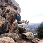 Hunter hanging from a boulder